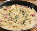 Macarrão penne gratinado ao forno com molho cremoso de requeijão, presunto, mussarela e parmesão ralado.