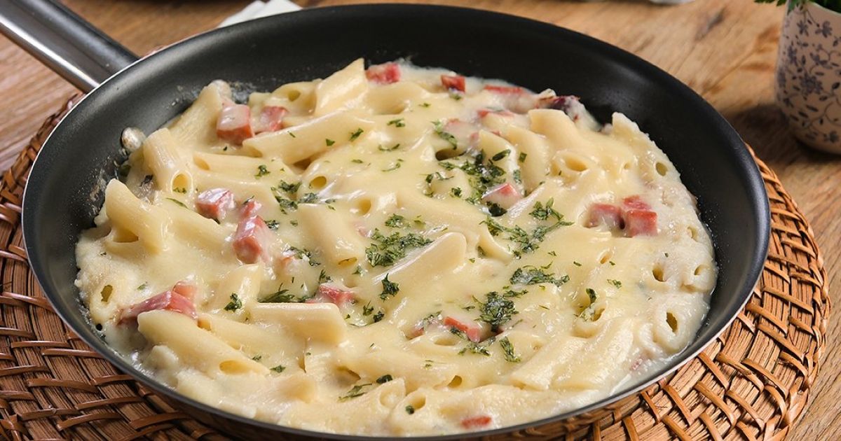 Macarrão penne gratinado ao forno com molho cremoso de requeijão, presunto, mussarela e parmesão ralado.