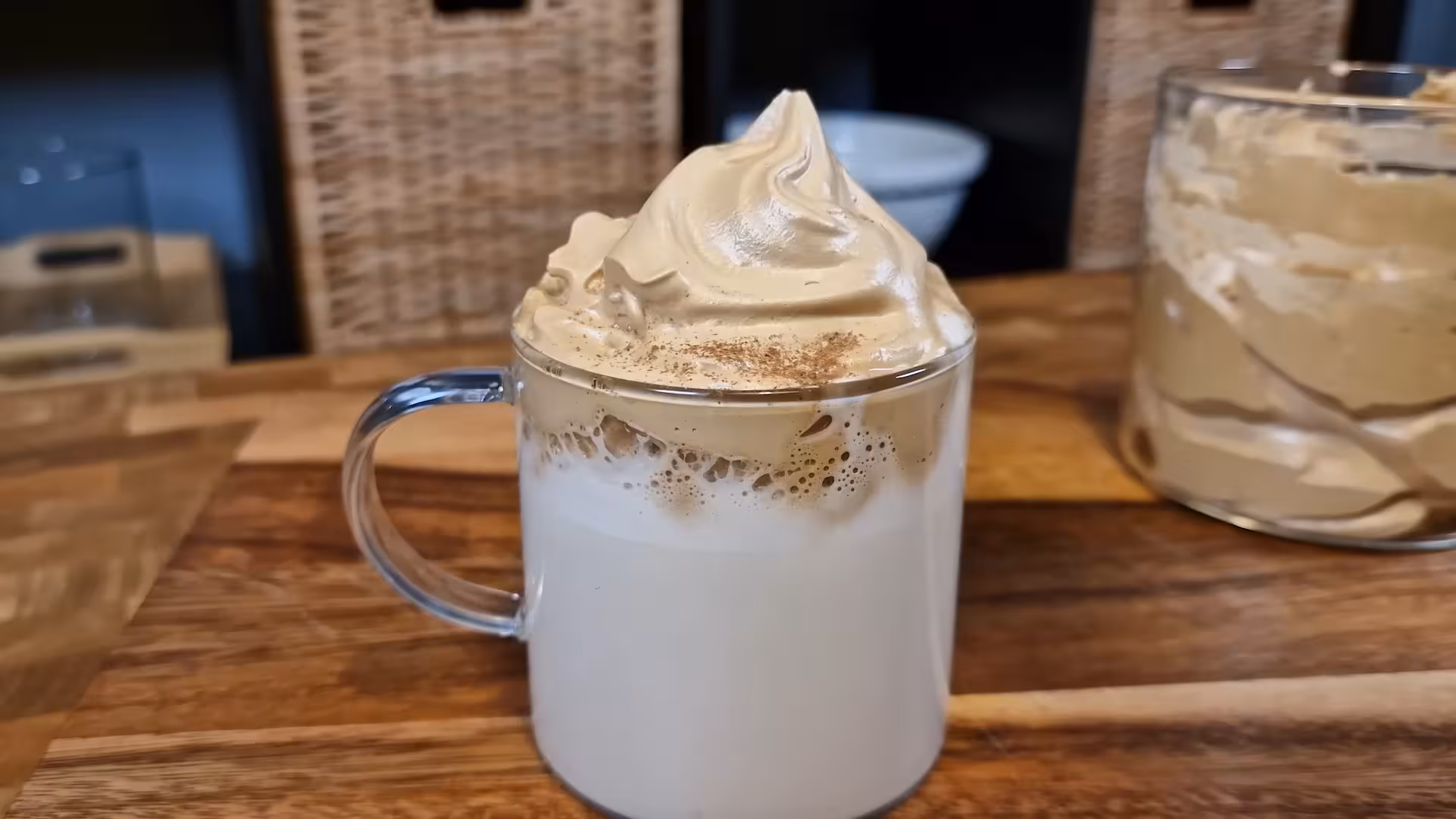 Copo de café cremoso caseiro servido com canela por cima.