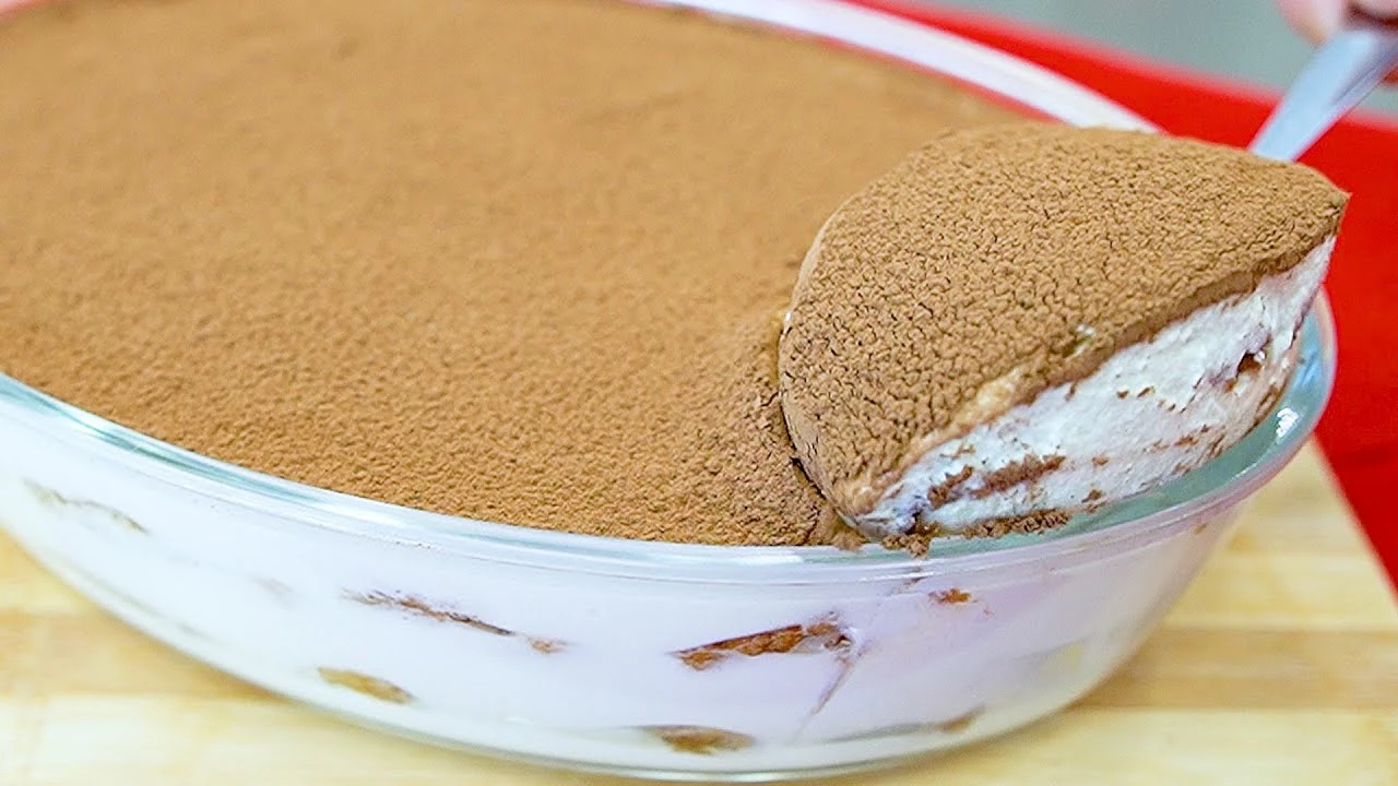 Tiramisu economico e fácil de preparar pronto e servido gelado em uma travessa de vidro.