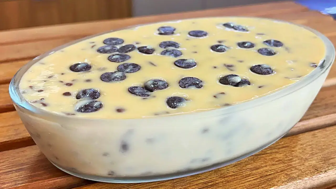 Sobremesa de creme com chocolate servido em refratalho de vidro.