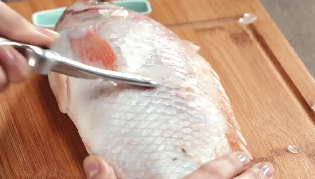 Foto tirando escamas de peixe